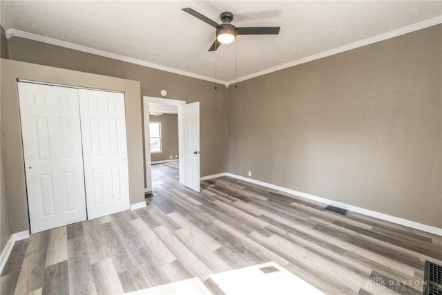 unfurnished bedroom with baseboards, a ceiling fan, a closet, and wood finished floors