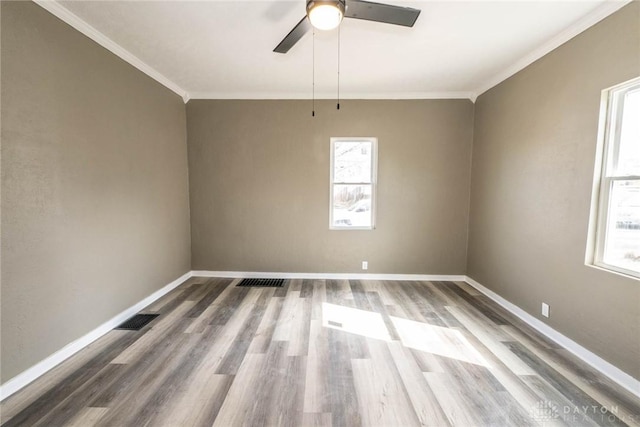unfurnished room with baseboards, a healthy amount of sunlight, and wood finished floors