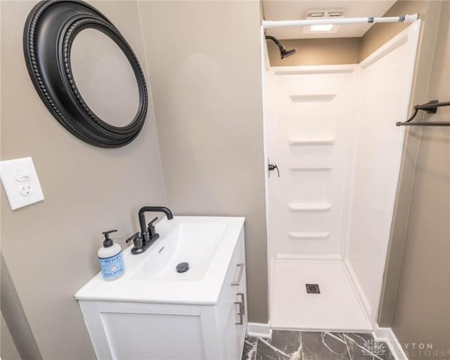 bathroom with vanity, baseboards, marble finish floor, and a stall shower