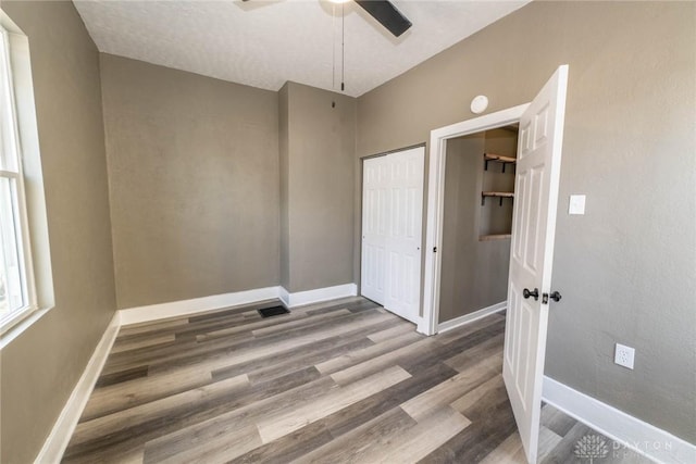 unfurnished bedroom featuring baseboards, ceiling fan, and wood finished floors