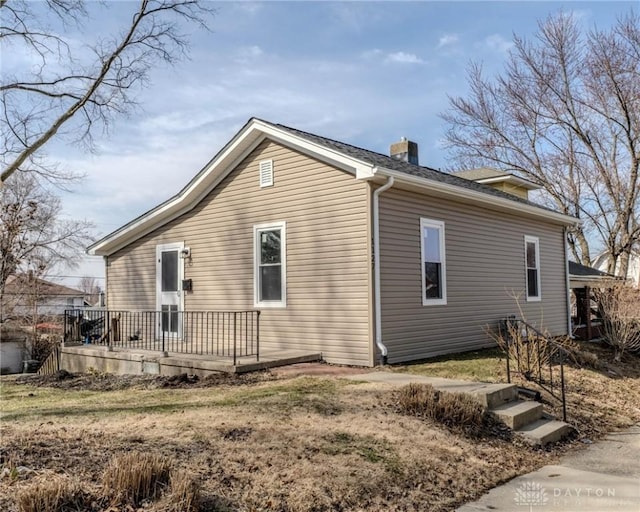 view of property exterior featuring a wooden deck and a chimney
