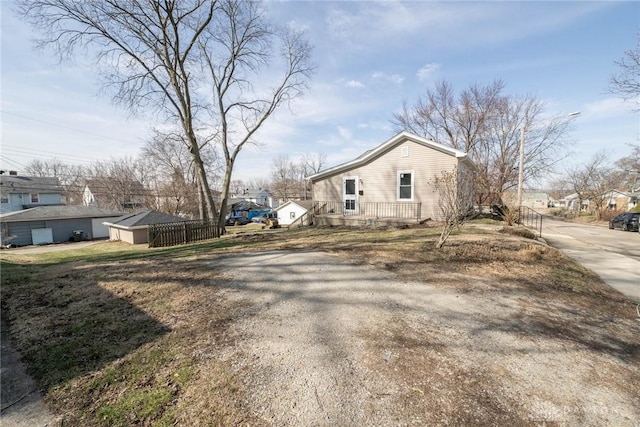 view of property exterior featuring fence, driveway, and a residential view