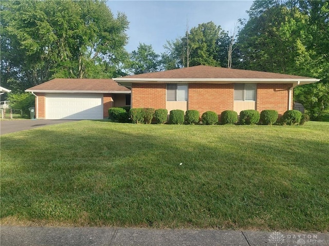 single story home with brick siding, an attached garage, and a front yard