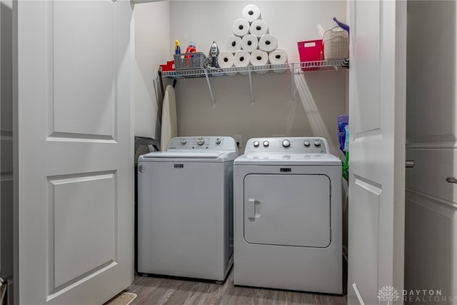 laundry area featuring independent washer and dryer, laundry area, and wood finished floors
