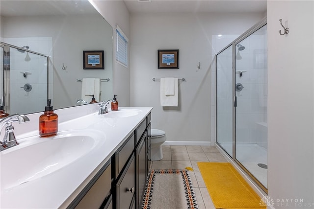 bathroom with double vanity, a sink, a stall shower, and tile patterned floors