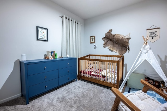 bedroom with baseboards, carpet, and a crib