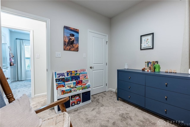 game room with baseboards and light carpet