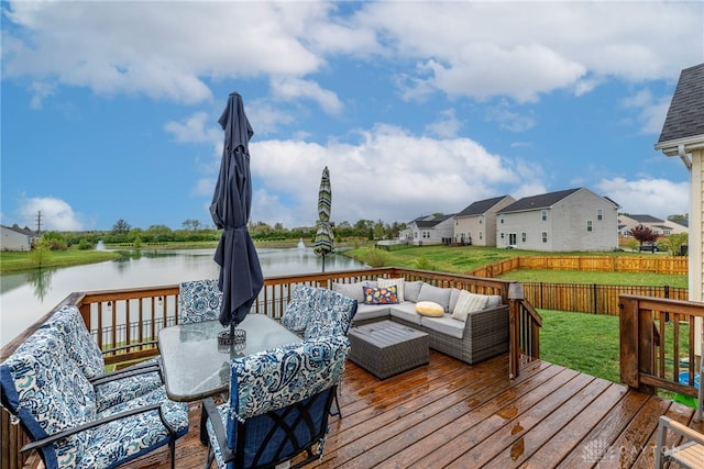 deck with outdoor dining area, an outdoor hangout area, a fenced backyard, a yard, and a water view