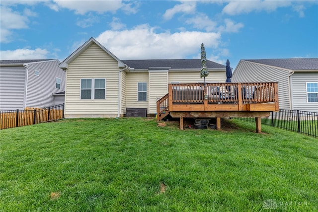 back of house with a fenced backyard, a lawn, and a deck