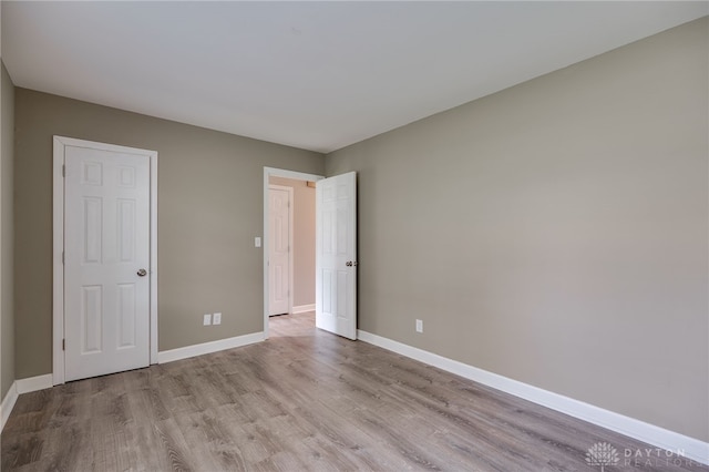 unfurnished bedroom with baseboards and wood finished floors