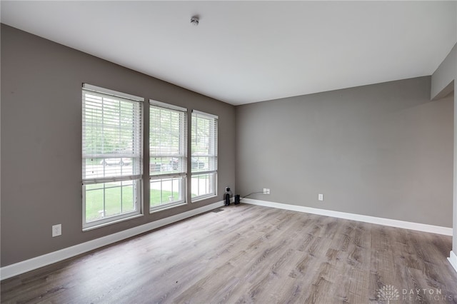 spare room featuring baseboards and wood finished floors