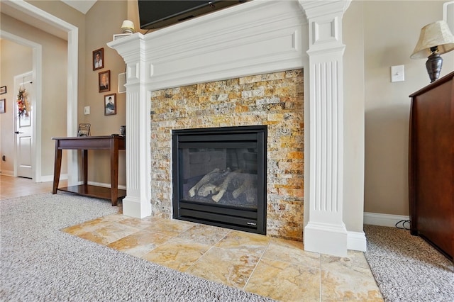 interior details with decorative columns, baseboards, and a glass covered fireplace