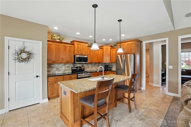 kitchen with baseboards, a sink, appliances with stainless steel finishes, and brown cabinets