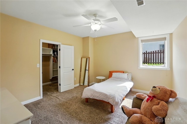 carpeted bedroom with a ceiling fan, visible vents, baseboards, a closet, and a spacious closet