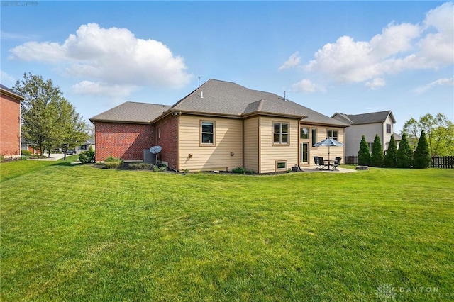 rear view of house featuring a lawn and a patio area