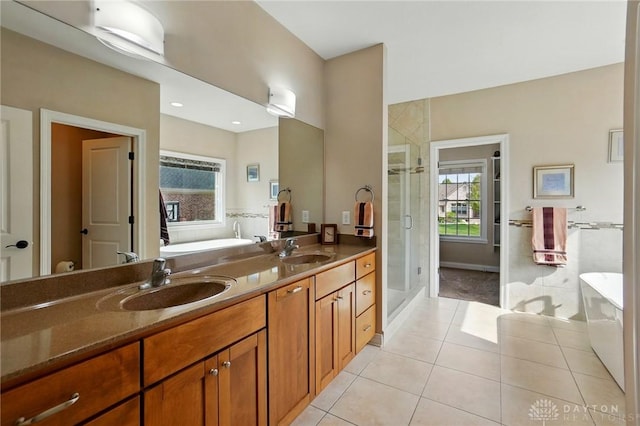 full bath featuring tile patterned flooring, a sink, a stall shower, and a soaking tub
