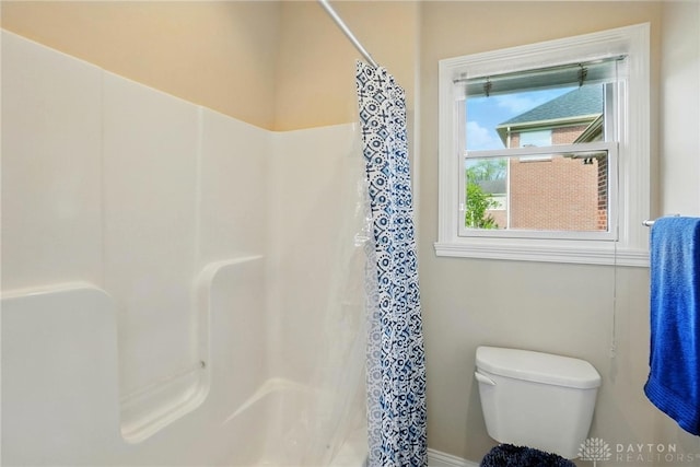 bathroom with toilet and a shower with curtain