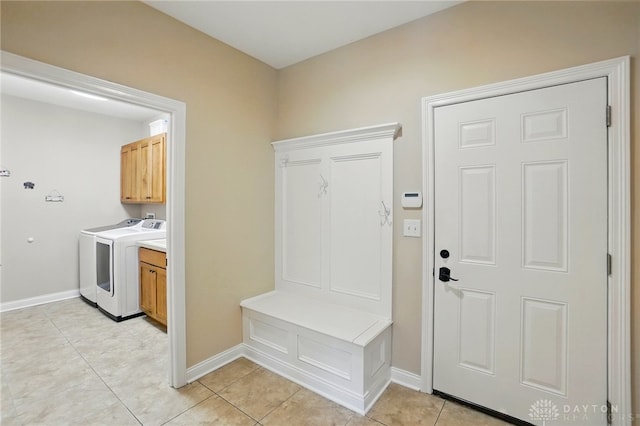 mudroom featuring washing machine and clothes dryer, baseboards, and light tile patterned floors