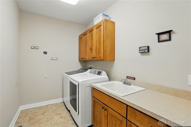 laundry area featuring a sink, separate washer and dryer, baseboards, and cabinet space