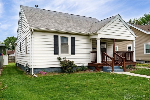 bungalow featuring covered porch, a shingled roof, and a front yard