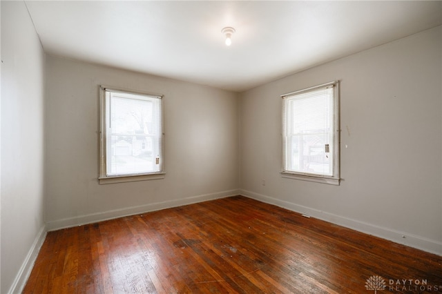 unfurnished room featuring baseboards and hardwood / wood-style flooring