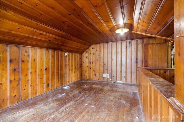 additional living space featuring visible vents, wood walls, vaulted ceiling, and wooden ceiling
