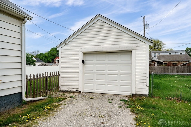detached garage with fence and gravel driveway