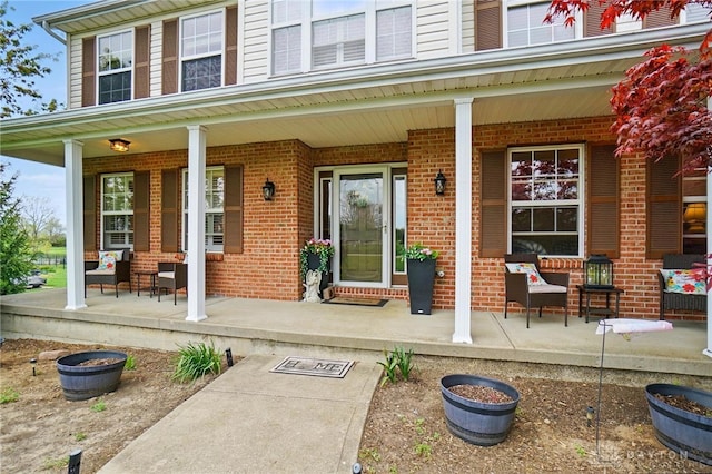 property entrance with covered porch and brick siding