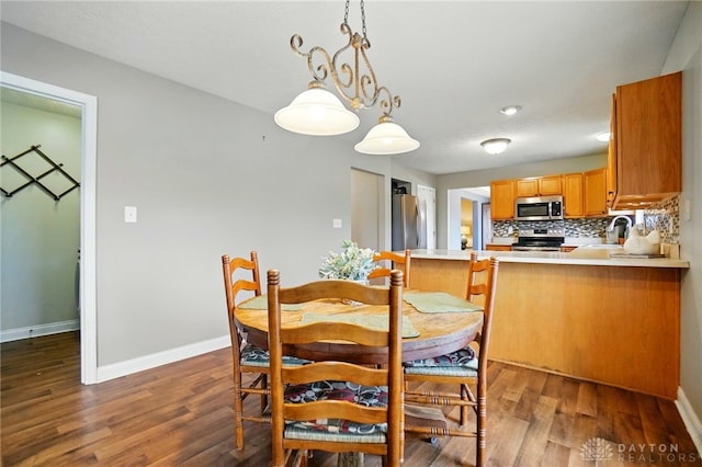 dining room with baseboards and wood finished floors