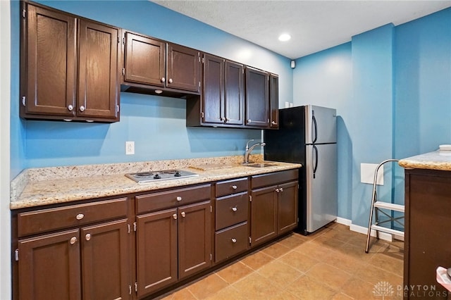 kitchen featuring dark brown cabinets, a sink, baseboards, stainless steel appliances, and recessed lighting