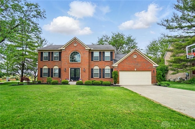 5497 Riverwalk Dr, Kings Mills, OH 45034 - colonial home featuring a garage, driveway, a front lawn, and brick siding