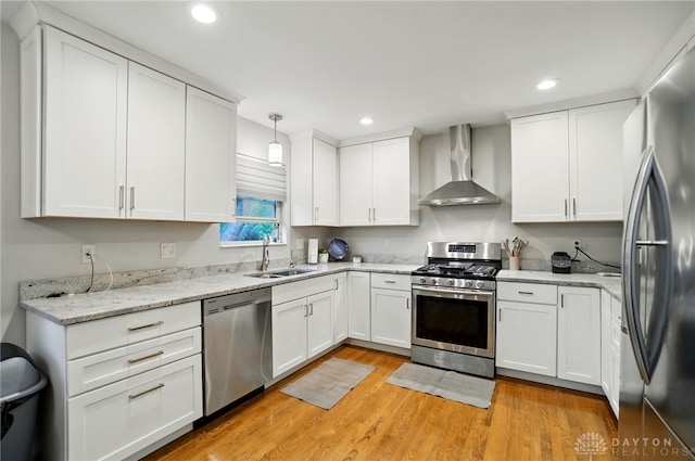 5497 Riverwalk Dr, Kings Mills, OH 45034 - kitchen featuring wall chimney range hood, appliances with stainless steel finishes, a sink, light wood-type flooring, and recessed lighting