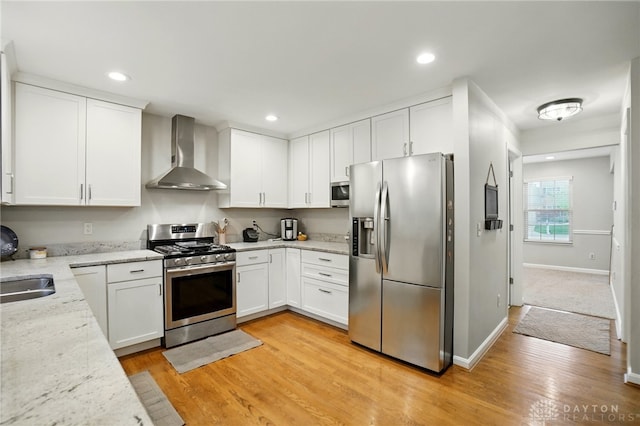 5497 Riverwalk Dr, Kings Mills, OH 45034 - kitchen with appliances with stainless steel finishes, wall chimney range hood, white cabinets, light wood-type flooring, and light stone countertops
