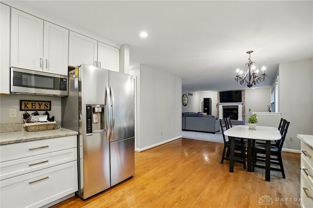 5497 Riverwalk Dr, Kings Mills, OH 45034 - kitchen featuring appliances with stainless steel finishes, baseboards, white cabinetry, a chandelier, and recessed lighting