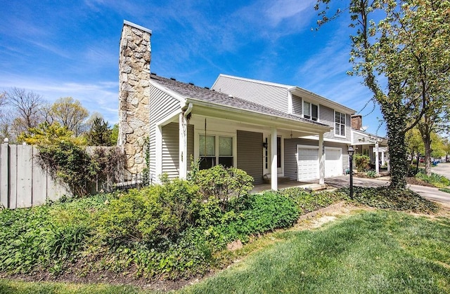 8464 Mcewen Rd, Washington Twp, OH 45458 - view of front of property with fence, an attached garage, a chimney, covered porch, and driveway