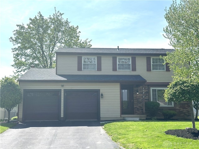 traditional-style house with an attached garage, driveway, and a front lawn