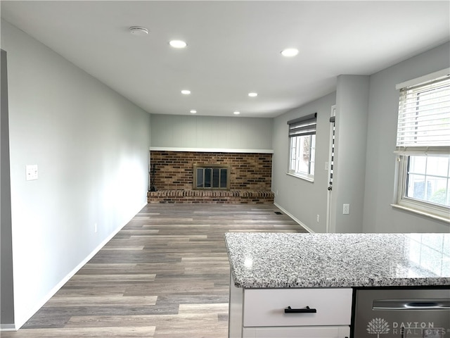 living room with a brick fireplace, recessed lighting, plenty of natural light, and wood finished floors