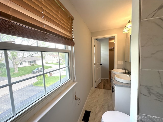 bathroom with baseboards, vanity, toilet, and marble finish floor
