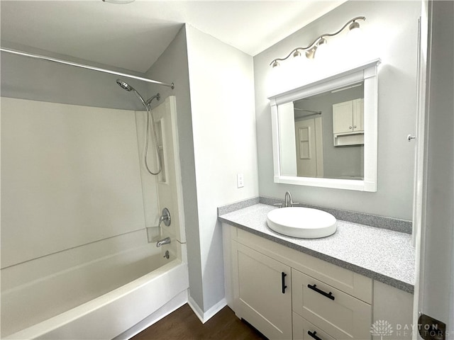 full bath featuring vanity, shower / bathtub combination, and wood finished floors