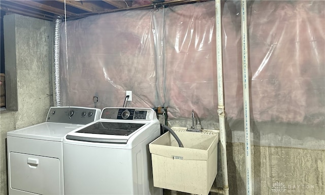 laundry room with washing machine and clothes dryer, laundry area, and a sink