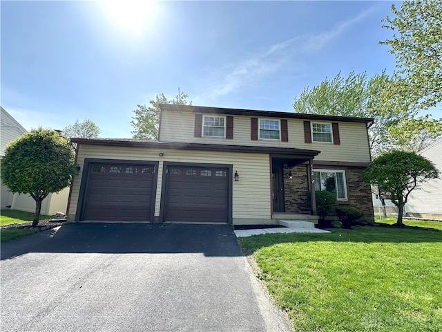 traditional home with a garage, a front yard, brick siding, and aphalt driveway