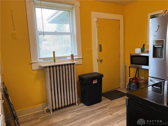 interior space featuring radiator and light wood-style floors