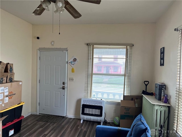 entrance foyer with ceiling fan, heating unit, a healthy amount of sunlight, and dark wood-type flooring