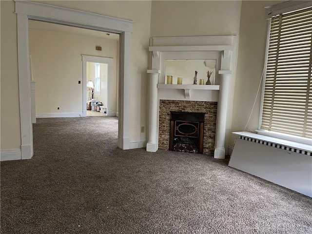 unfurnished living room with baseboards, carpet, and a tile fireplace