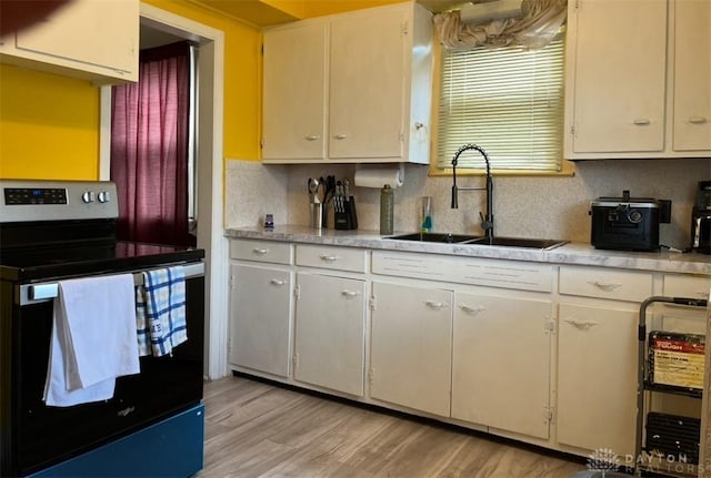 kitchen featuring a sink, light countertops, electric stove, light wood-type flooring, and backsplash