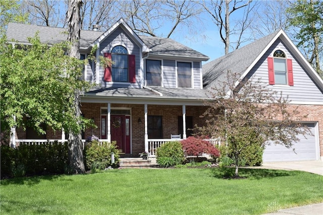 view of front of home featuring a garage, covered porch, a front yard, brick siding, and driveway