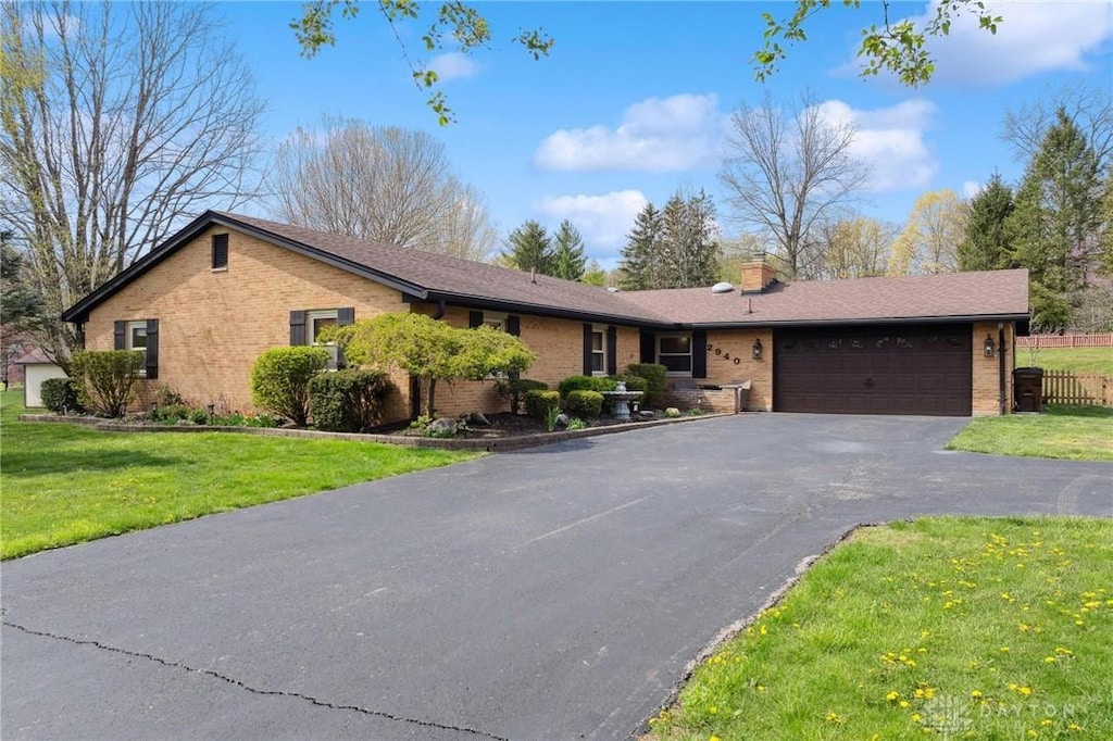 2940 Rhett Dr, Beavercreek, OH 45434 - ranch-style home featuring brick siding, an attached garage, a front lawn, and aphalt driveway