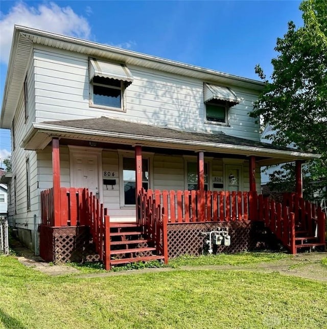 view of front of house featuring covered porch and a front yard