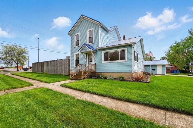 traditional-style home with a chimney, fence, a front yard, and metal roof
