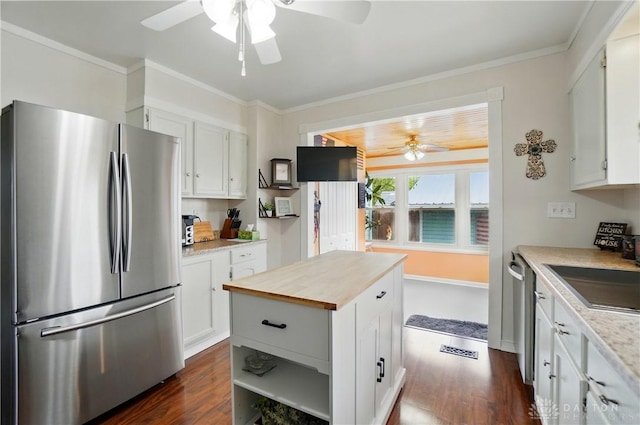 kitchen featuring butcher block countertops, ceiling fan, dark wood-style floors, a sink, and appliances with stainless steel finishes